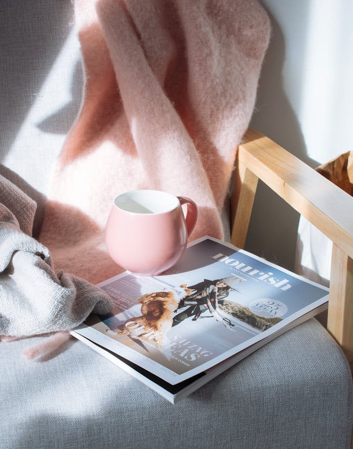 why-choose-us A warm scene featuring a pink mug and magazine on a wooden chair, bathed in sunlight.