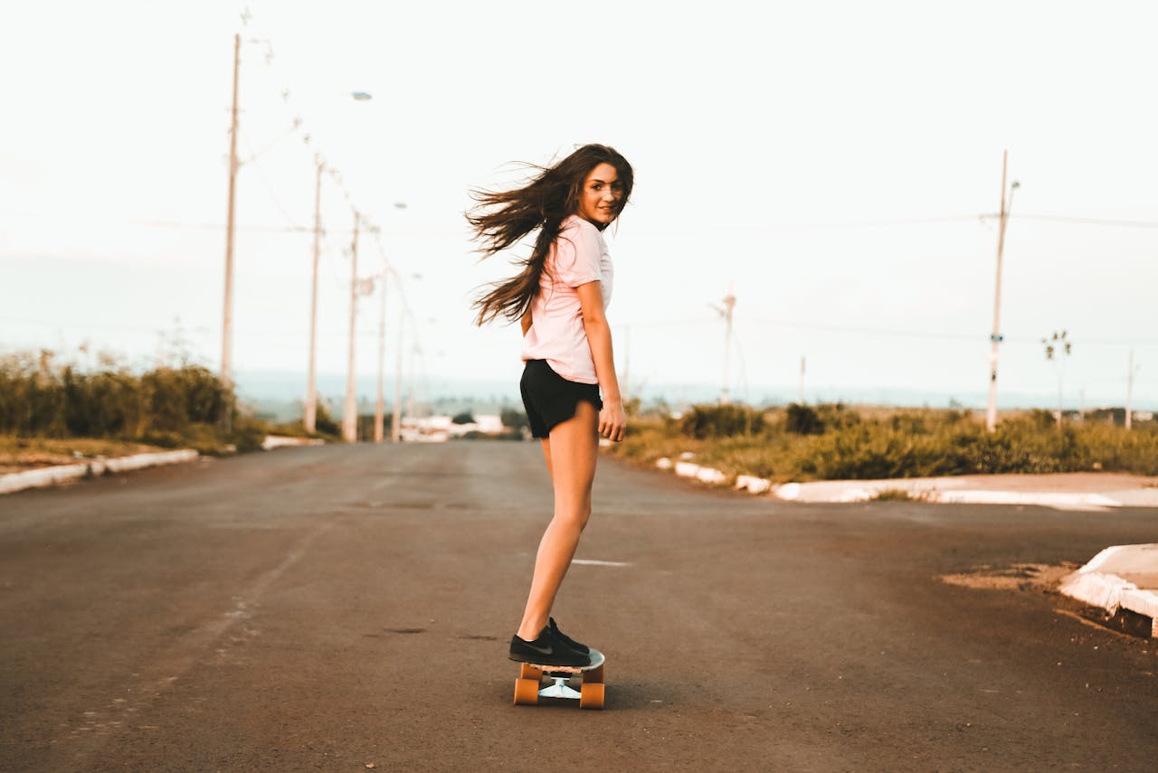 about-us Enjoy a moment of freedom as a young woman skateboards down an empty road.
